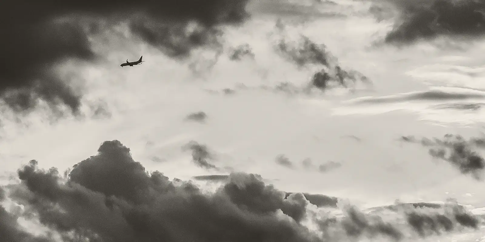 An aircraft crossing a clouded evening sky.