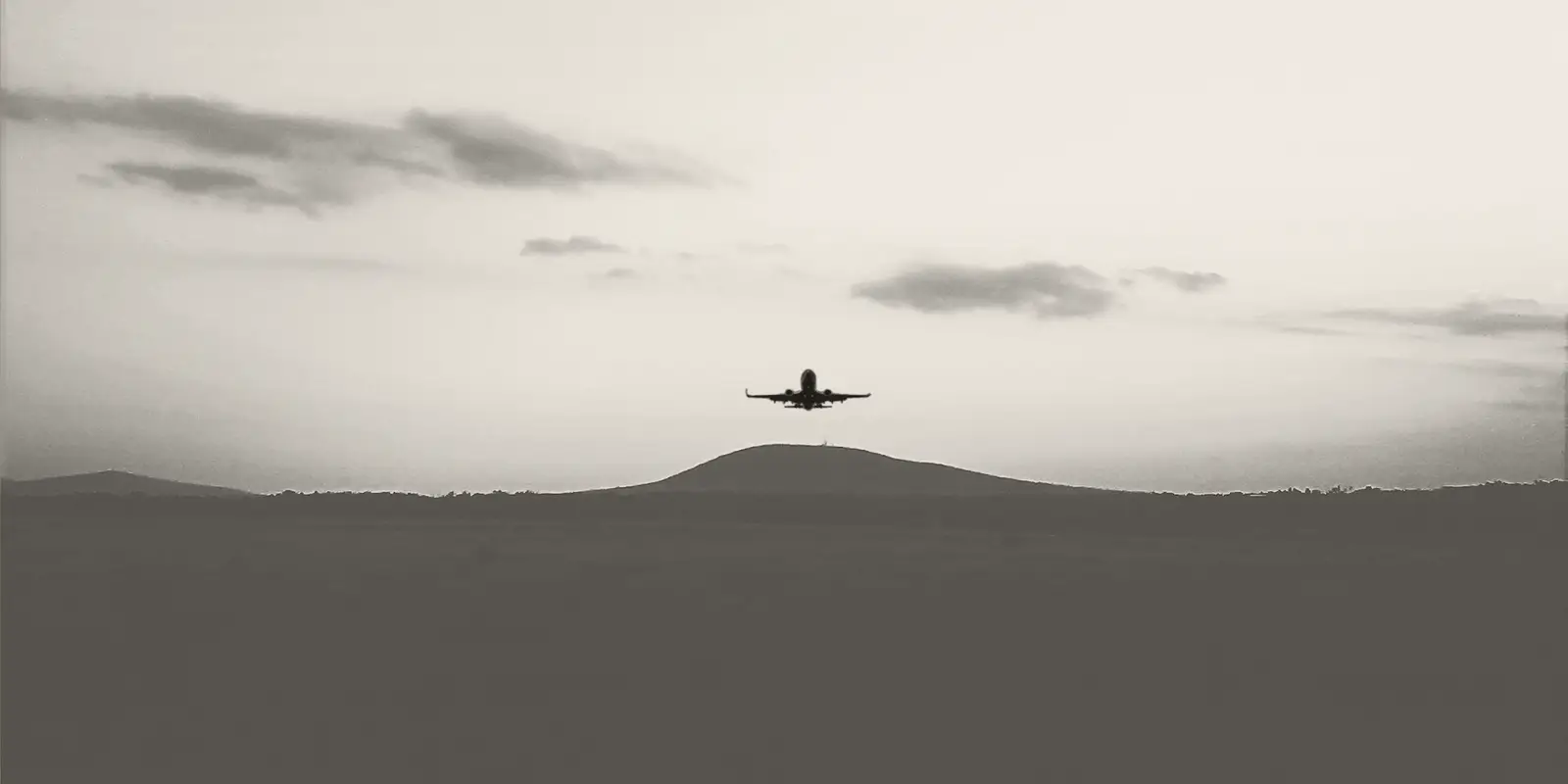 An aircraft climbing away against an evening sky.