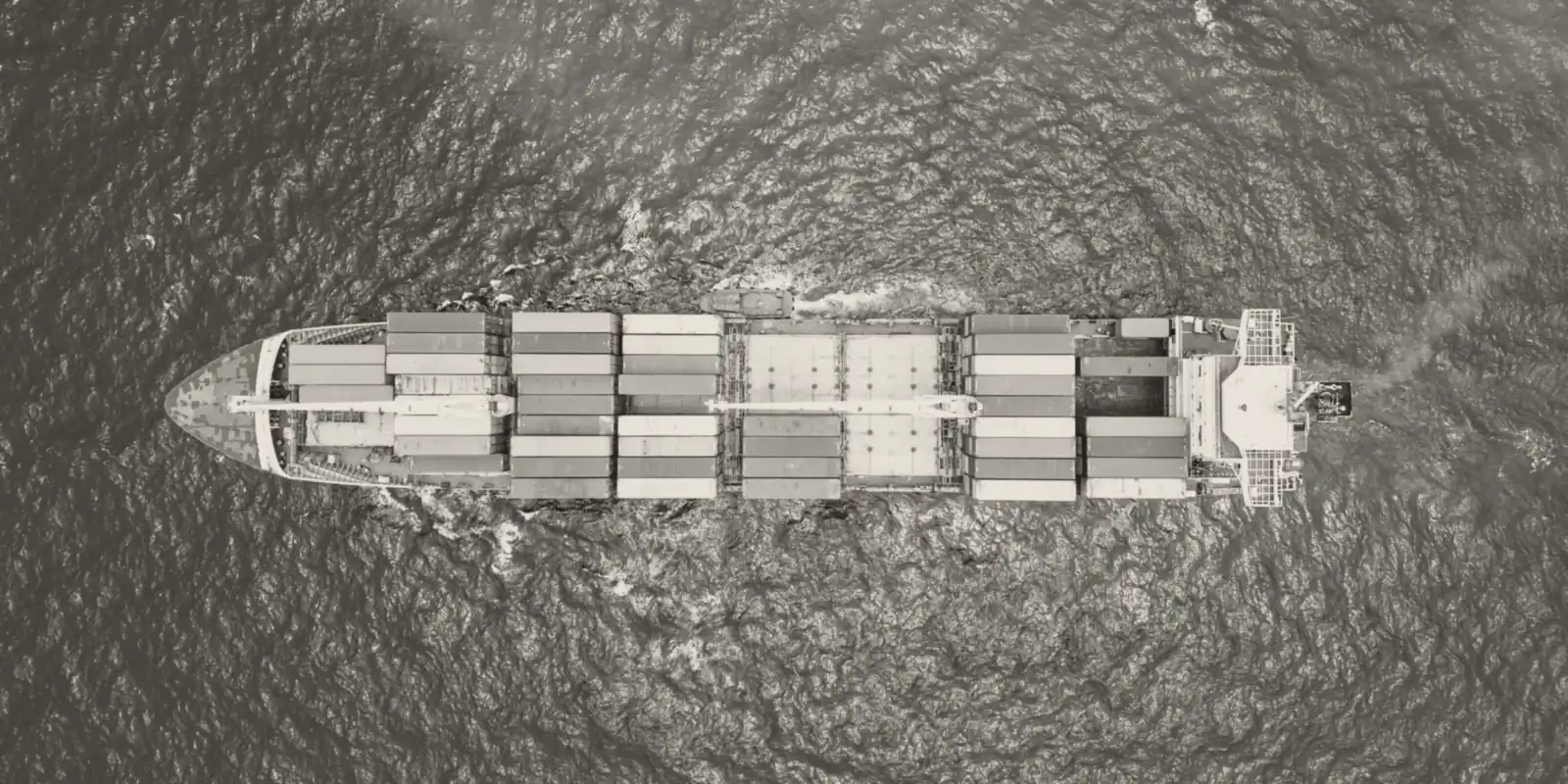 A container ship at sea, seen from directly above.